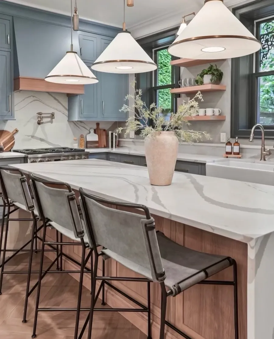 Custom blue kitchen with marble island and brass pendant lights